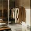 Elegante Kleidungsstücke hängen auf einer Kleiderstange in einem modernen Showroom für Kollektionsmanagement.